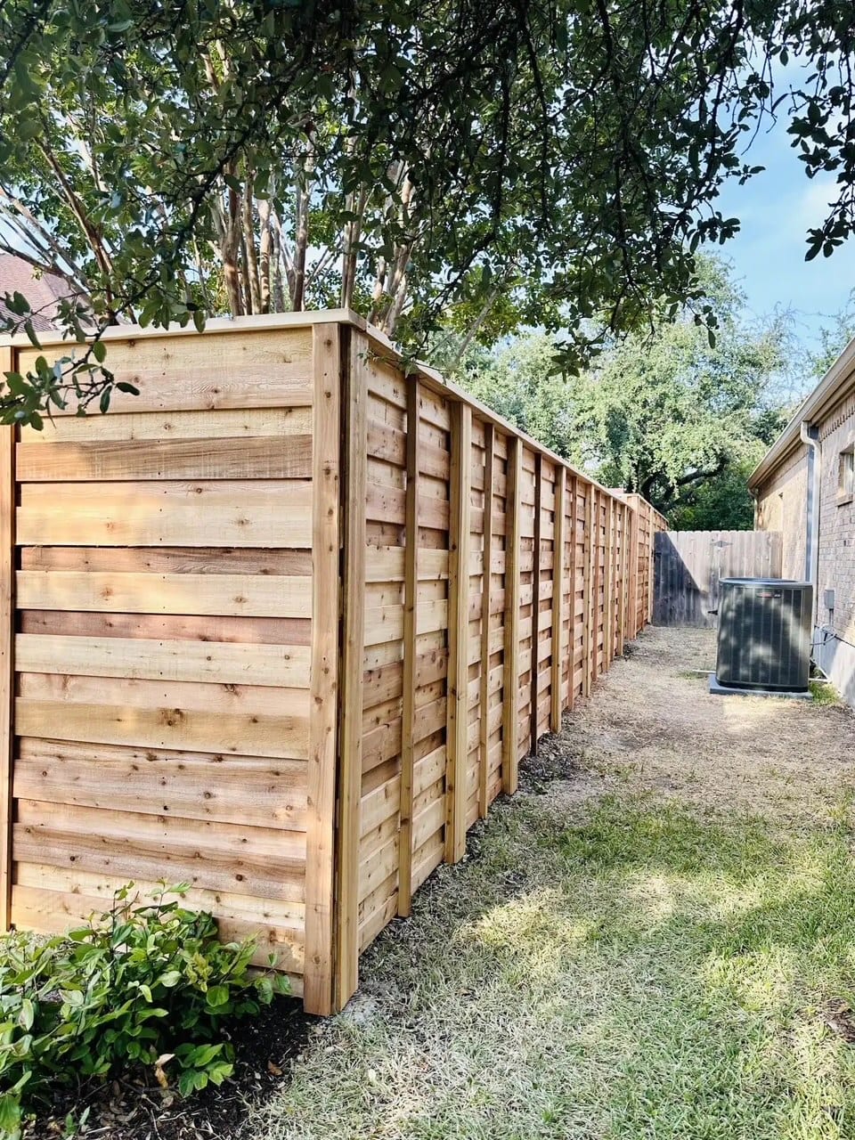 Cedar privacy fence against blue Texas sky in Fulshear